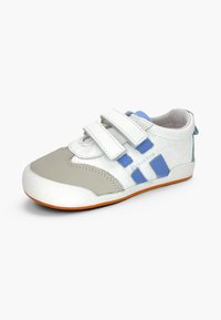 Baskets pour enfants blanches et grises avec des bandes latérales bleues, une semelle orange et deux bandes Velcro, présentées sur un fond uni.