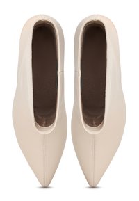 Chaussures beige à bout pointu, sans lacets, avec dessus en cuir lisse, vues de dessus sur fond blanc.