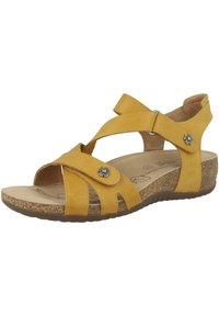 Sandalo giallo in pelle con cinturini incrociati, fibbia laterale regolabile, suola in sughero, soletta leggermente testurizzata e decorazione metallica a forma di fiore.