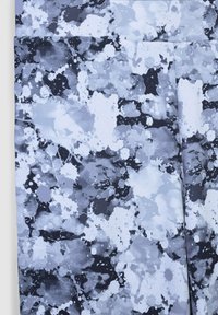 Szare i czarne legginsy z wzorem plamowym o różnych fakturach i odcieniach, wykonane z elastycznego, oddychającego materiału.