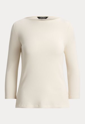 Slonokoščeno bela dolgoročna majica z rebrastim vzorcem in širokim izrezom. Ima oprijeten kroj in subtilno teksturo, izdelana iz mehke, raztegljive tkanine.
