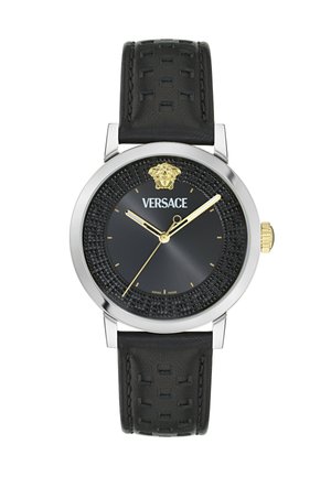 Versace armbandsur med svart texturerad urtavla, guld Medusa-logotyp vid 12 o'clock, guld visare och svart perforerat läderarmband.