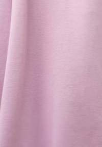 Tissu rose doux avec une texture lisse, présentant des plis délicats et un motif de tricot régulier.