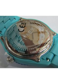 Zegarek Timex z turkusowym paskiem silikonowym, stalowym tyłem i tarczą w kolorze srebrnym z białymi znacznikami godzin i logo.