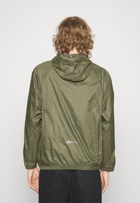 Olive green hooded jacket made of lightweight, glossy material with elastic cuffs and bottom hem. Features a small logo at the back.