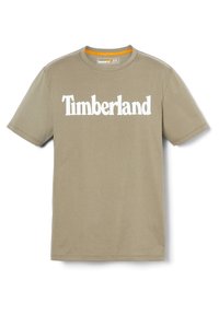 Kaki bomulds t-shirt med korte ærmer, der har et stort hvidt "Timberland" logo på forsiden og en rund halsudskæring.