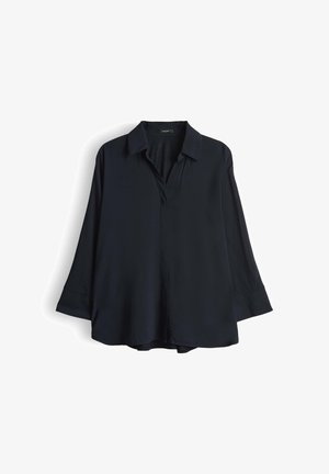Blusa nera a maniche lunghe con colletto, scollatura a V e texture morbida. Orlo dritto con spacchi laterali, progettata per un fit rilassato.