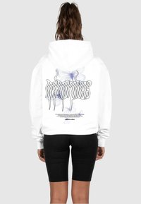 Weißer Hoodie mit grafischem Design und blauen Schmetterlingsillustrationen sowie fettgedrucktem Text auf dem Rücken. Glattes Material, entspannter Schnitt.