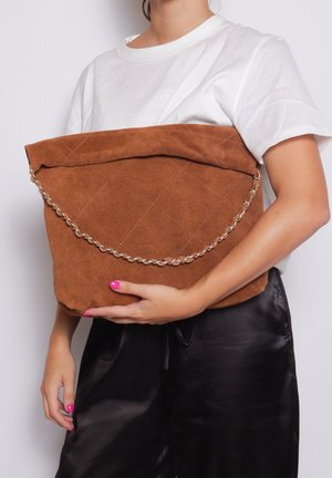 Borsa tote in suede marrone con un design trapuntato, dotata di una tracolla in catena argentata. La borsa ha una texture morbida e una forma morbida.