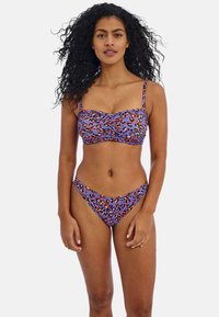 Violetti bikinit, joissa on oranssi-mustaa leopardikuosia. Yläosassa on kyhätty muoto ja ohutolkaimet; alaosassa on korkeakattoinen lahje.