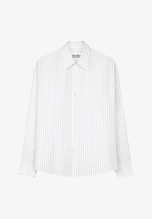 Biała koszula z długim rękawem na guziki, z cienkimi pionowymi czarnymi paskami i szpiczastym kołnierzykiem, rozłożona na płasko na białym tle.