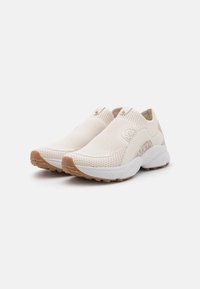 Svetle béžové slip-on tenisky s texturovaným síťovinovým svrškem, gumovou podrážkou a jemným logem. Obsahují elastický límec pro snadné obouvání.