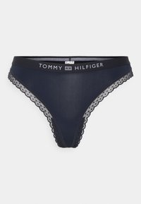 Tamnoplave tange s čipkastim rubom i crnim pojasom na kojem se nalazi logo "TOMMY HILFIGER" u bijeloj boji. Glatki dizajn od tkanine.
