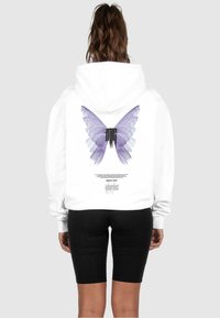 Weißer Hoodie mit einem großen lila Schmetterlingsdesign auf dem Rücken und schwarzem Text darunter. Der Stoff wirkt weich und lässig.