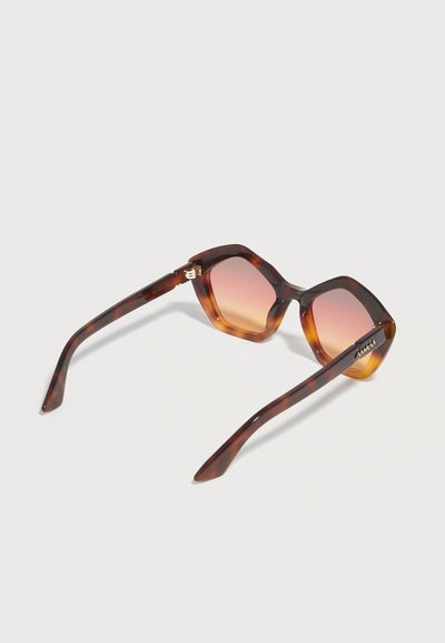 Tortoiseshell oversized square sunglasses with gradient brown-orange lenses and branded gold detail on temple arms on a plain background.