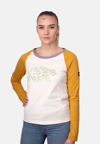 Camicia a maniche lunghe con corpo crema, maniche gialle e colletto lavanda. Presenta una grafica di un orso floreale in verde con fiori gialli e bianchi.