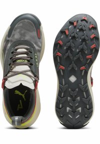 Chaussures de sport grises avec un motif camouflage, dotées d'un dessus léger, de lacets décoratifs, d'une semelle rembourrée et d'un profil texturé pour une meilleure adhérence.