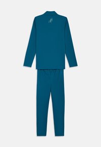 Μπλε-πρασινή μπλούζα με μακριά μανίκια και σετ παντελονιού σε συνδυασμό, με μικρό λευκό αβέβαιο λογότυπο στο επάνω πίσω μέρος, απεικονιζόμενο σε λευκό φόντο.