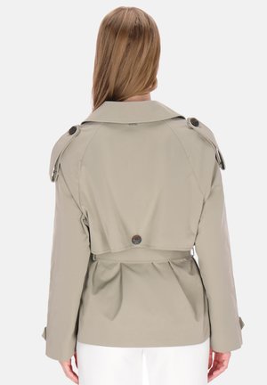 Beiger Trenchcoat mit figurbetontem Schnitt, Schulterklappen und einer Knopfverzierung am Rücken. Glatte Textur mit Klappenakzenten und tailliertem Bund.