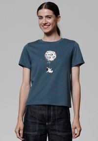 Teal katoenen T-shirt met korte mouwen, voorzien van een witte astronautafbeelding die een ballon vasthoudt in de vorm van een gekratert maan.