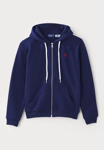 Marineblaue Zip-Hoodie mit einer vorderen Taschenöffnung, weißen Kordeln und einem roten Logo auf der linken Brust. Weiches Baumwollmaterial, entspannte Passform.
