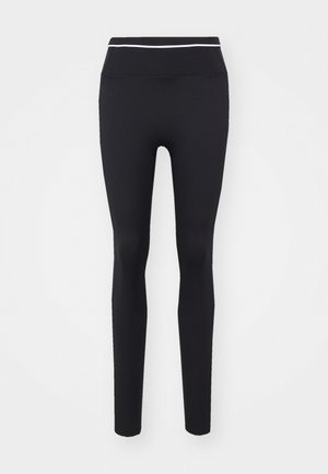Black leggings made of stretchy fabric, featuring a high waist with a thin white stripe at the top. Smooth texture and form-fitting design.