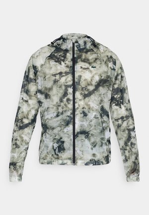 Jaqueta leve e com fecho, em um padrão abstrato de verde e cinza. Apresenta um colarinho alto e capuz ajustável. Feita de um tecido liso e resistente à água.