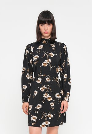 Robe noire à fleurs avec des manches longues, un col froncé et une taille cintrée. Présente des fleurs blanches et brunes sur un fond sombre.