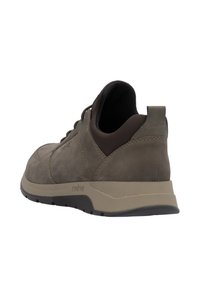 Brązowe skórzane sneakersy z gumową podeszwą, zaokrąglonym noskiem i sznurowanym zapięciem. Posiadają wyścielony kołnierz oraz teksturowane akcenty po bokach.