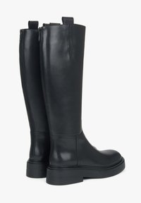 Zwarte leren kniehoge laarzen met een gladde afwerking, zijritsen, trek lussen aan de bovenkant en een dikke, gestructureerde zool.