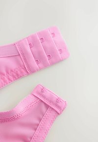 Roosad kangasrihmad reguleeritavate konks- ja silma kinnitustega, millel on tekstuurse pinnaga ja siledad servad mugavuse ja toe tagamiseks.