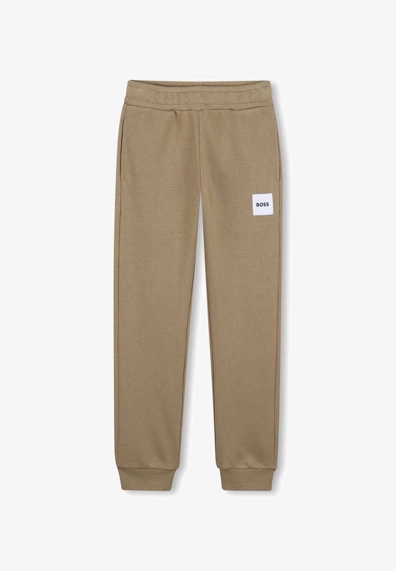 Pantalon de survêtement marron clair fuselé avec taille et poignets élastiques, poches latérales, et un patch blanc portant l'inscription "BOSS" sur la cuisse droite.