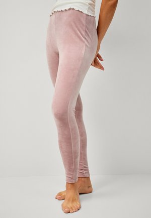 Zachte roze fluwelen leggings met een gladde textuur, een aansluitend ontwerp en een geschulpte tailleband, getoond met blote voeten.
