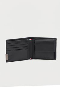Zwarte leren bi-fold portemonnee opengelegd met vier kaartsleuven en een muntzak met flap op een witte achtergrond.