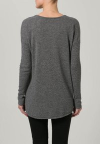 Pull à manches longues gris en matière tricotée douce, doté d'une coupe décontractée, d'un ourlet arrondi et d'accents côtelés aux manches.