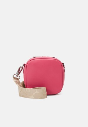 Petit sac bandoulière carré rose avec une large sangle réglable beige présentant un motif floral subtil et une fermeture à fermoir en métal argenté.