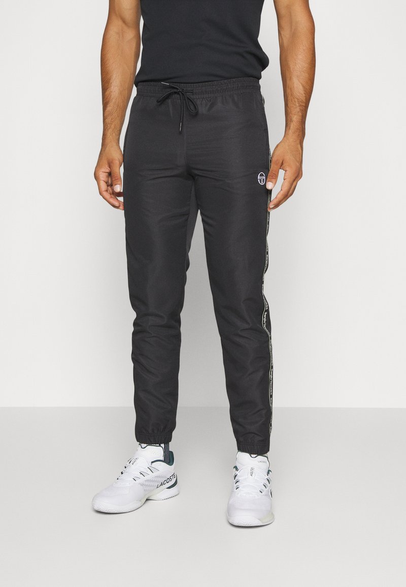 Pantalons de jogging noirs en tissu lisse, avec une taille élastique à cordon de serrage et des bandes latérales avec un détail de logo.