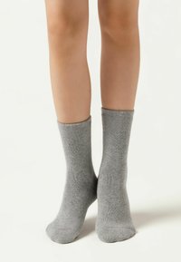 Šedé bavlněné ponožky s žebrovanou strukturou, kotníkového střihu a hladkým povrchem, s elastickými manžetami pro pohodlné nošení.