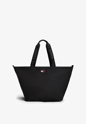 Sort tote bag med en bred rektangulær form, lavet af slidstærkt stof. Har to robuste håndtag og et logo-patch på forsiden.