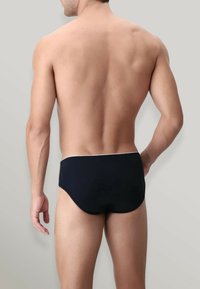Slip da nuoto neri con taglio basso, dotati di una vita bianca a contrasto. Texture liscia, progettati per un fit aerodinamico e comfort.