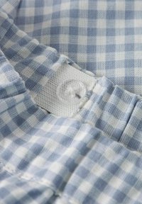 Hele sinine ja valge ginghami kangas, millel on nööpkinnitus. Omab pehmet tekstuuri ja kokkupandud servi paindlikuks sobivuseks.