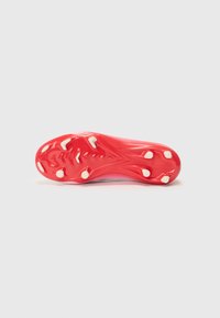 Semelle de chaussure de soccer rouge avec des crampons circulaires blancs, présentant une forme courbée et une surface texturée pour une traction et une adhérence optimales.