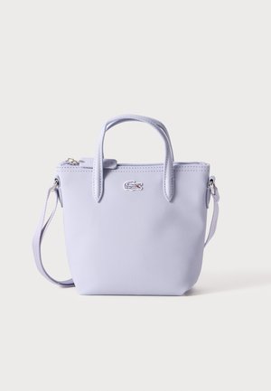 Sac à main lilas avec finition texturée, double poignées, bandoulière détachable et fermeture zippée. Il présente un petit accent de logo sur le devant.