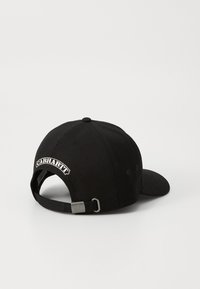 Čierna čiapka vyrobená z bavlny s zakriveným kríkom, nastaviteľným pásom a bielym vyšívaným logom "Carhartt" na zadnej strane. Hladký povrch.