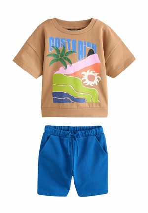 Bruine katoenen t-shirt met een kleurrafisch Costa Rica ontwerp, gecombineerd met blauwe katoenen shorts met een elastische tailleband en zakken.