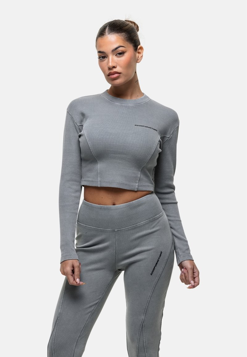 Set di due pezzi grigio a coste composto da un top cropped a maniche lunghe e leggings a vita alta. Il top presenta un logo discreto e un design aderente.