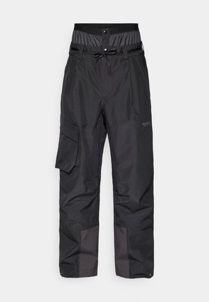 Pantalons noirs imperméables avec taille ajustable, poches latérales zippées, jambes inférieures renforcées et texture lisse. Conception légère et durable.