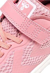 Rosa träningsskor med ett mesh-överdrag, texturerade detaljer, platta snören och justerbart rem med en logotab vid hälen.