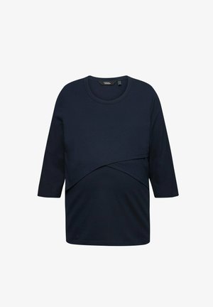 Marineblaues Umstandstop mit 3/4-Ärmeln, Rundhalsausschnitt und einem geschichteten Design für zusätzlichen Komfort. Hergestellt aus weichem, dehnbarem Stoff mit glatter Textur.