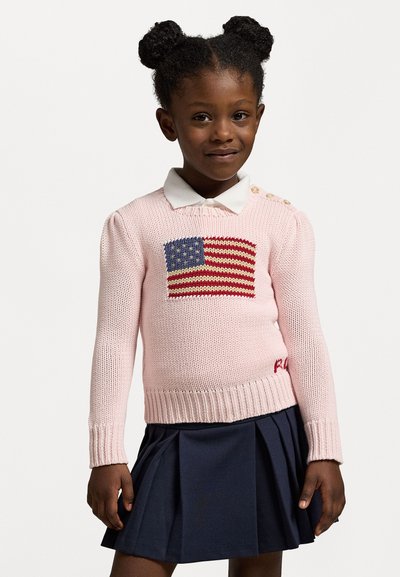 Suéter rosa tricotado com um design da bandeira americana no peito, com um colarinho branco e botões decorativos em um dos ombros.